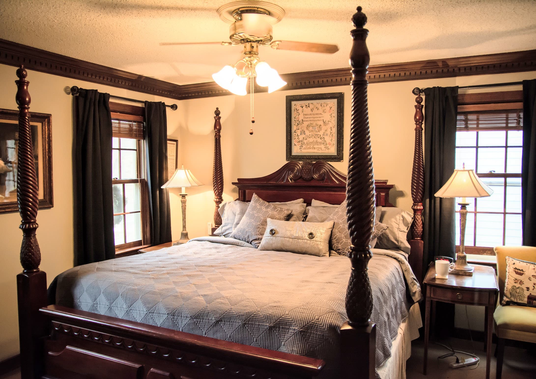 Cozy bedroom with a four-poster bed, decorated in warm tones and soft lighting.