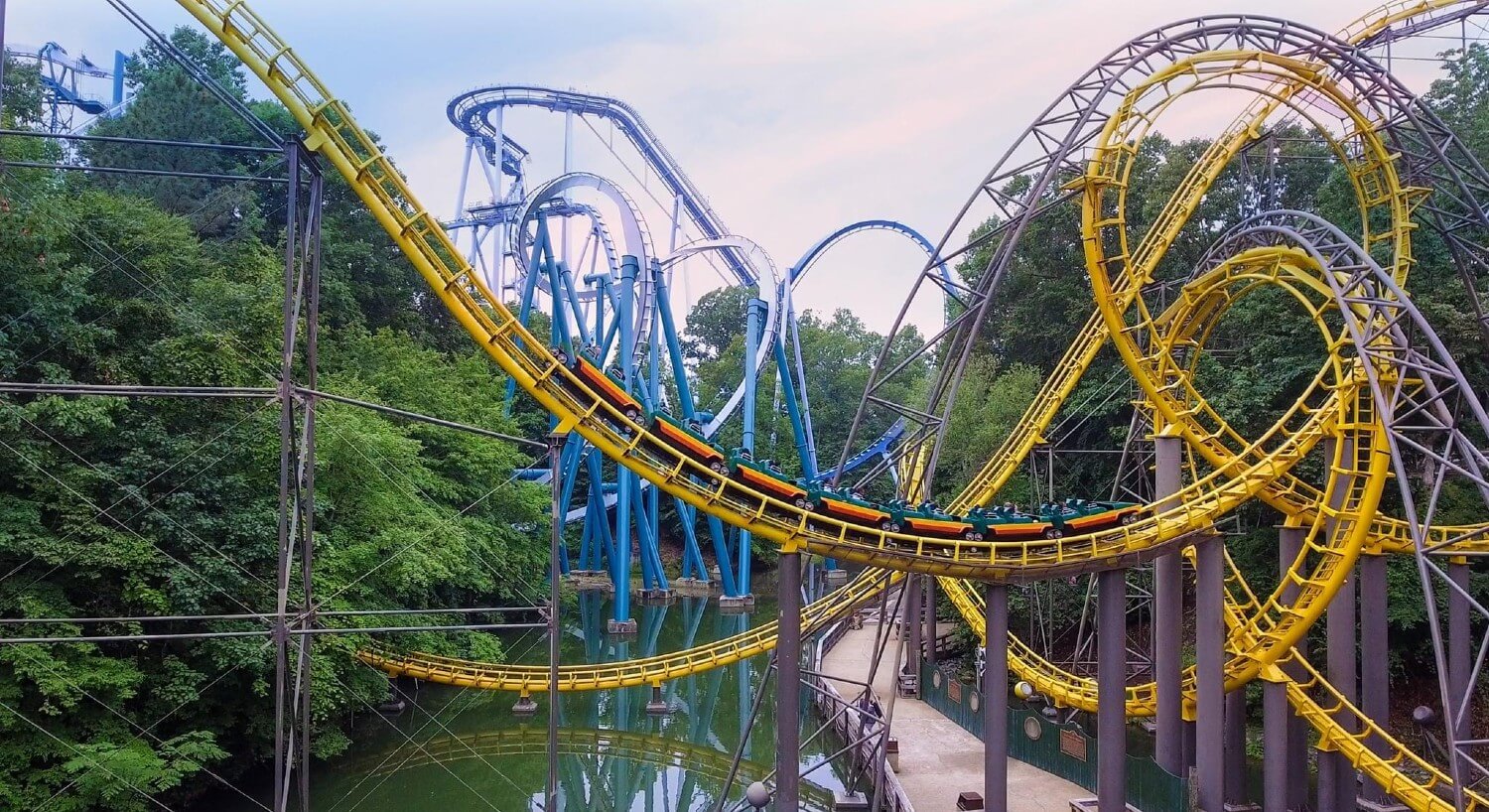 Large twisting blue and yellow roller coaster rails over water