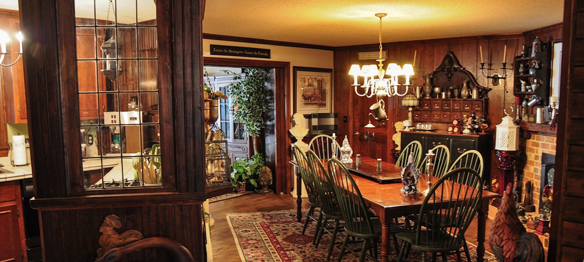 Kitchen and dining room area of a historic home with table and eight chairs and antique decor